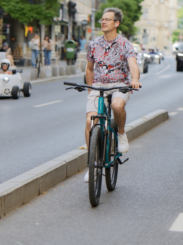 13 - Person enjoying a sunny day while cycling through a busy city street